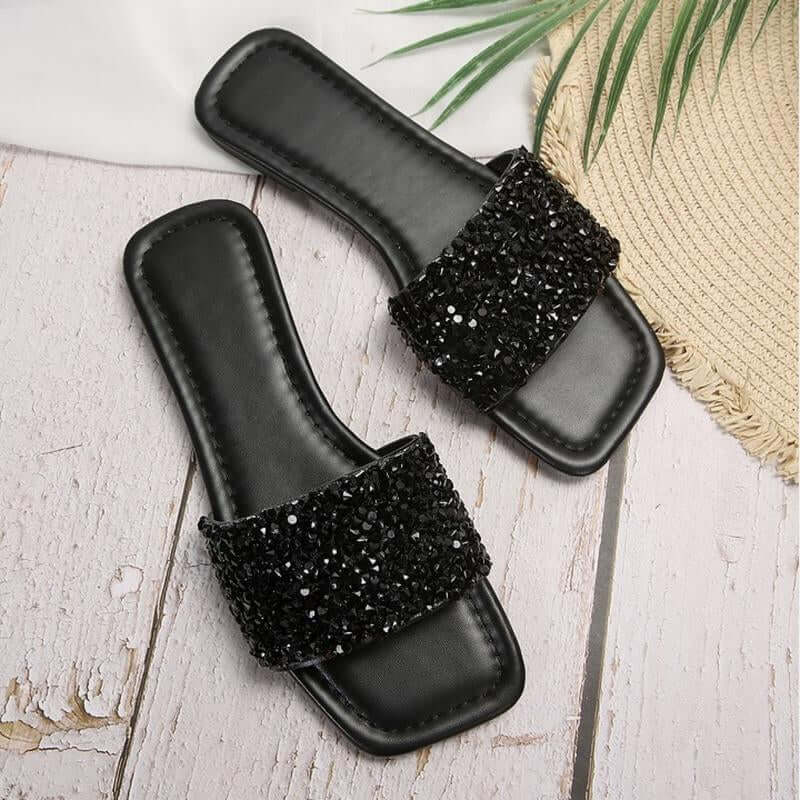 Chic black rhinestone women's slippers with open toe and flat sole, perfect for summer beach days.