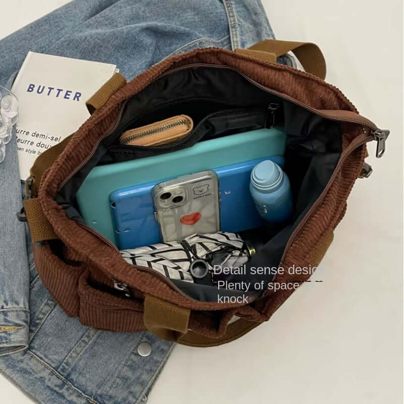 Inside view of a large corduroy tote bag showing ample space for essentials like a laptop, water bottle, and wallet.