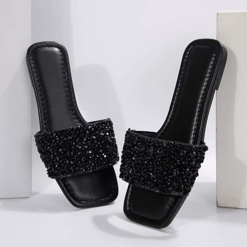 Chic black rhinestone women's slippers with open toe and flat sole, perfect for summer beach days.