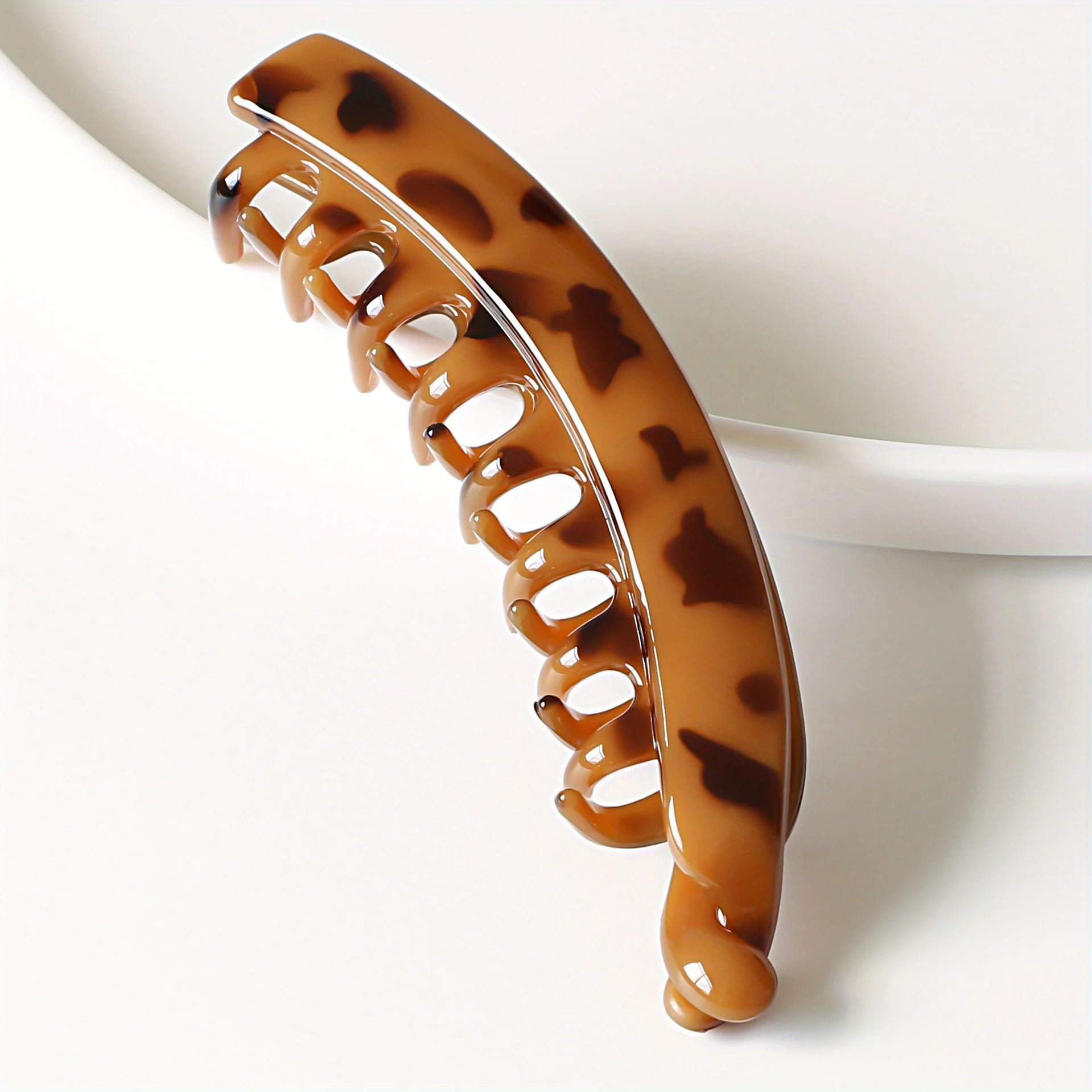 Matte brown banana hair clip, fish-shaped ponytail holder, stylish women's hair accessory.