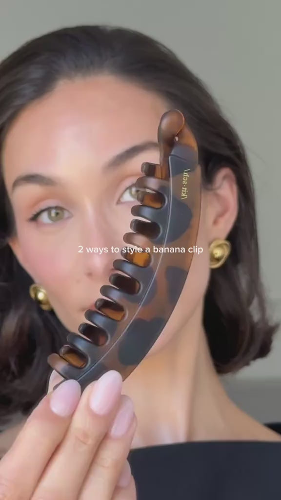 Woman showcasing a matte banana hair clip with styling tips in a fashionable hairstyle.